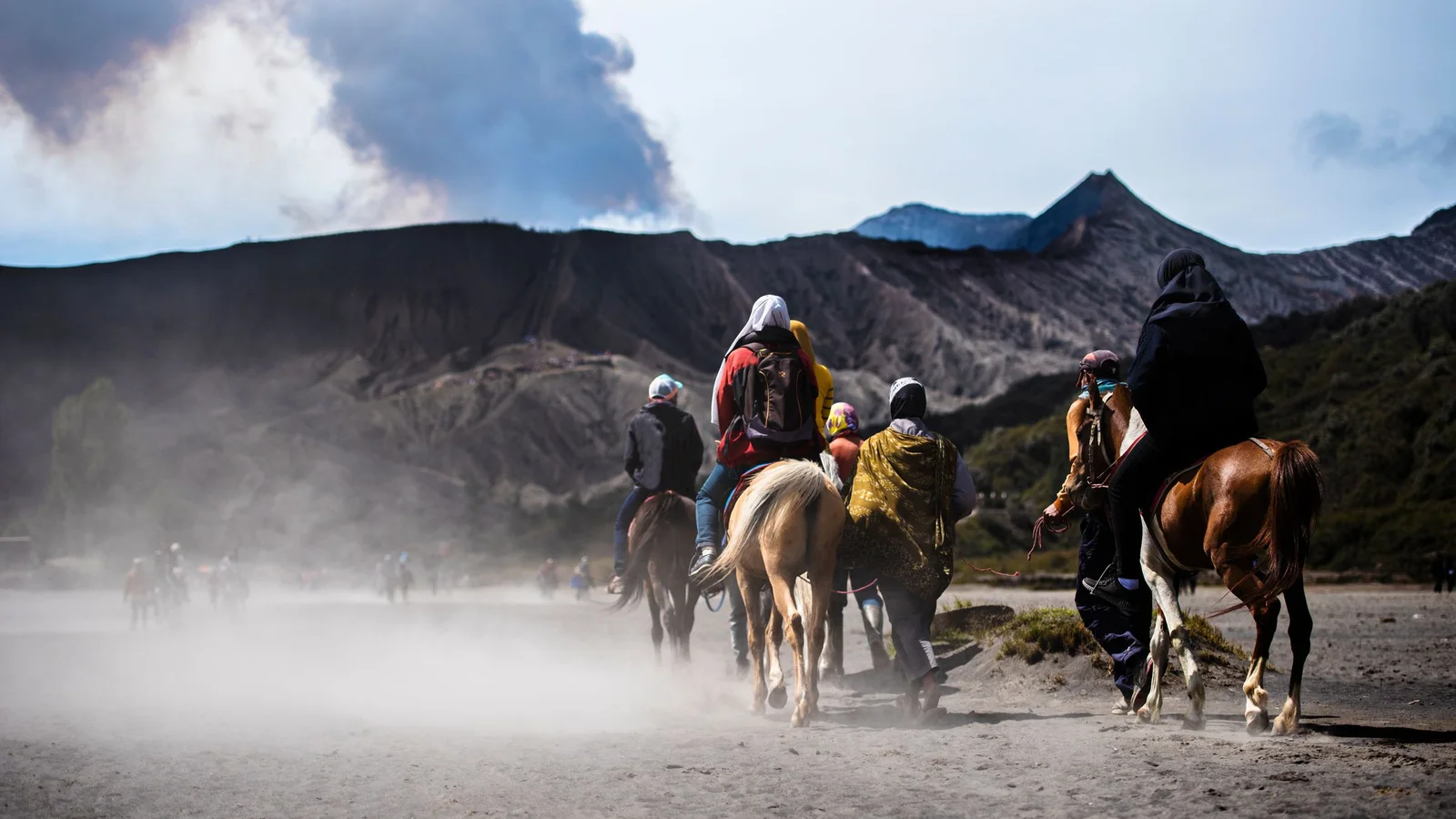 A rider on horseback crossing the sea of sand at Mount Bromo