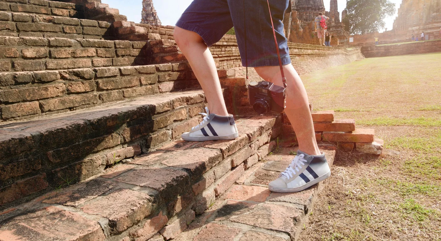 A visitor climbing a stone stairway at Borobudur